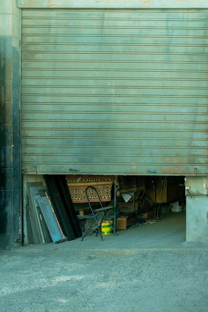 mobile-02 Partial view of a garage entrance with various items stored inside, exuding an urban industrial vibe.