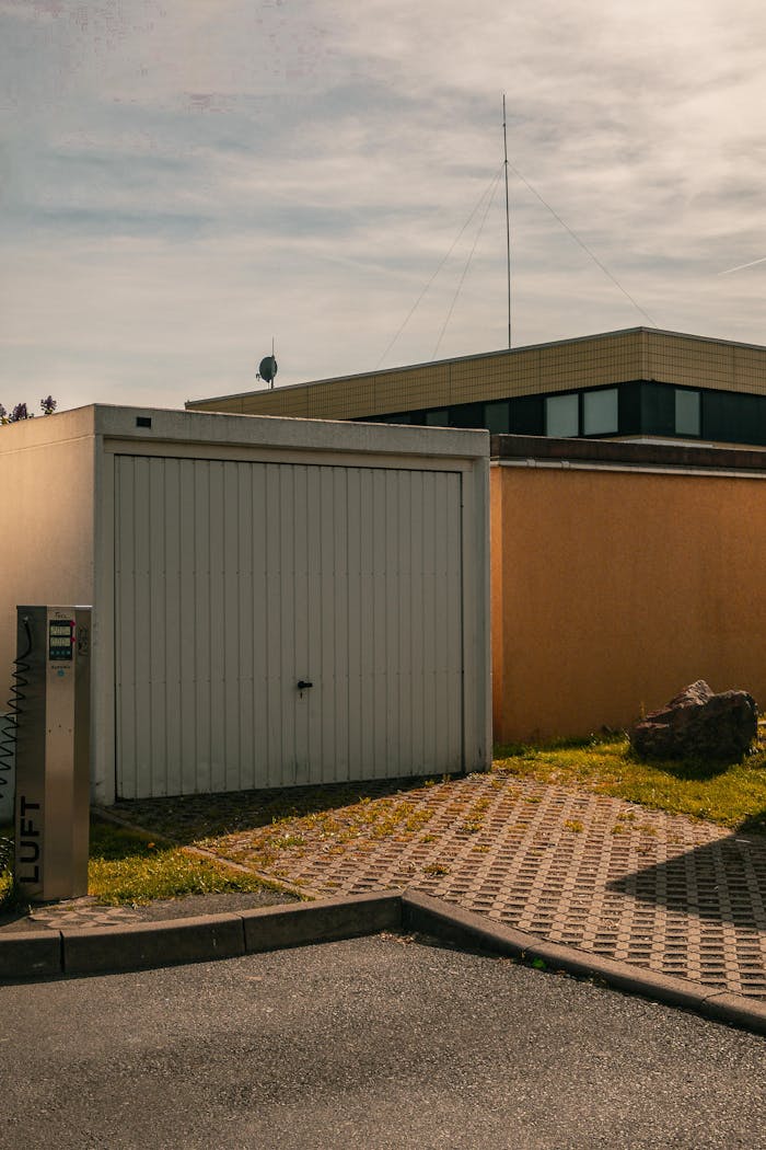 why-choose-us A minimalist urban scene featuring a closed garage, paving stones, and clean lines under a sunny sky.