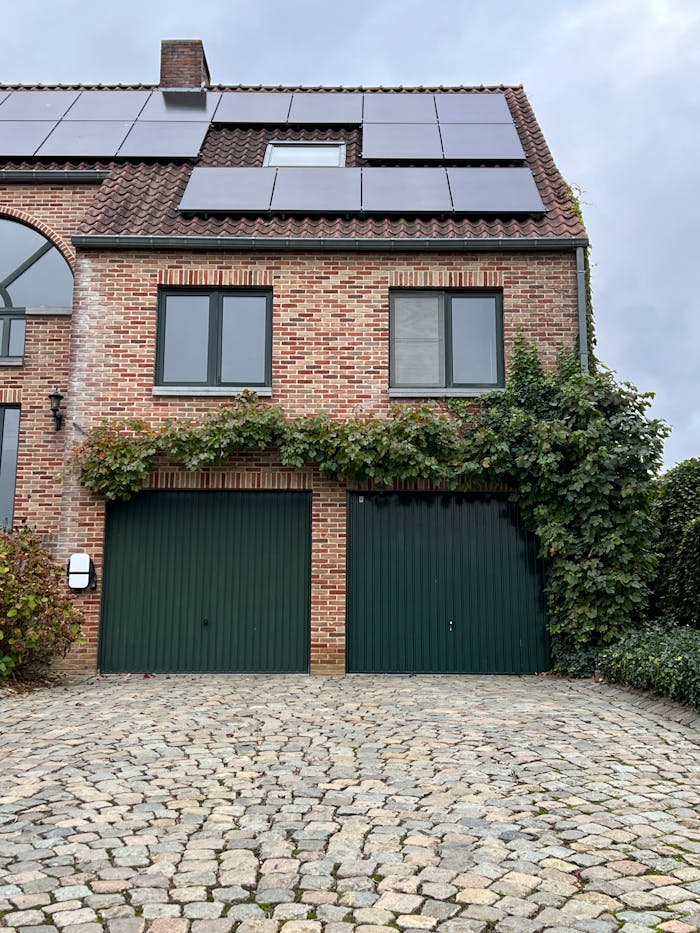 creative Charming brick house with solar panels and ivy-covered garage. Eco-friendly architecture.