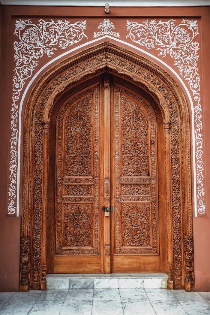 team-04 Beautifully carved wooden door with ornate arched frame and intricate details.