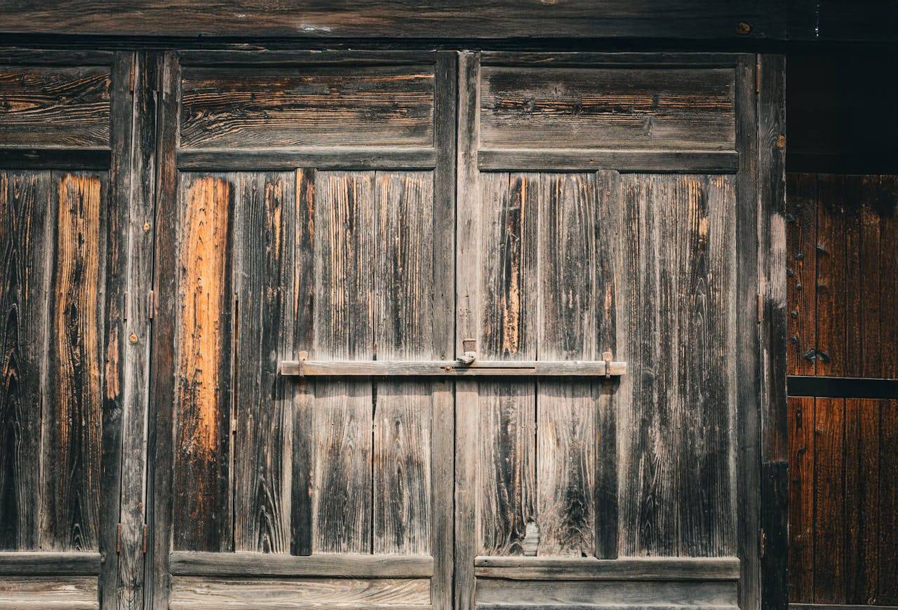services-04 A close-up of a rustic, weathered wooden door, showcasing vintage craftsmanship and texture.