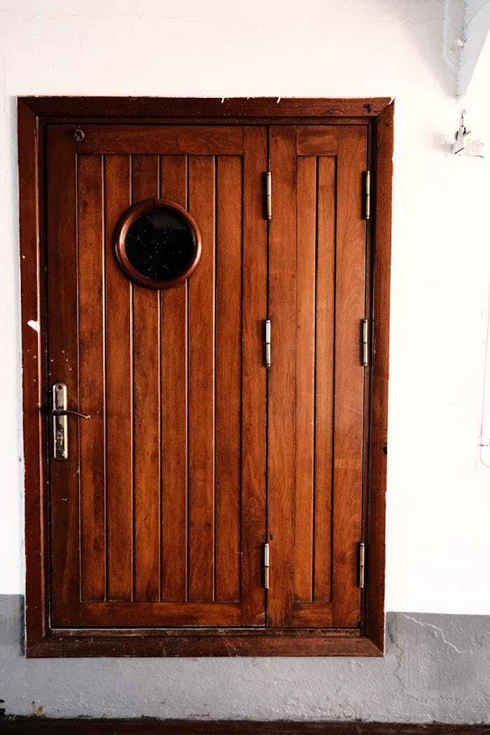 Elegant wooden door featuring a round window, showcasing rustic design indoors.