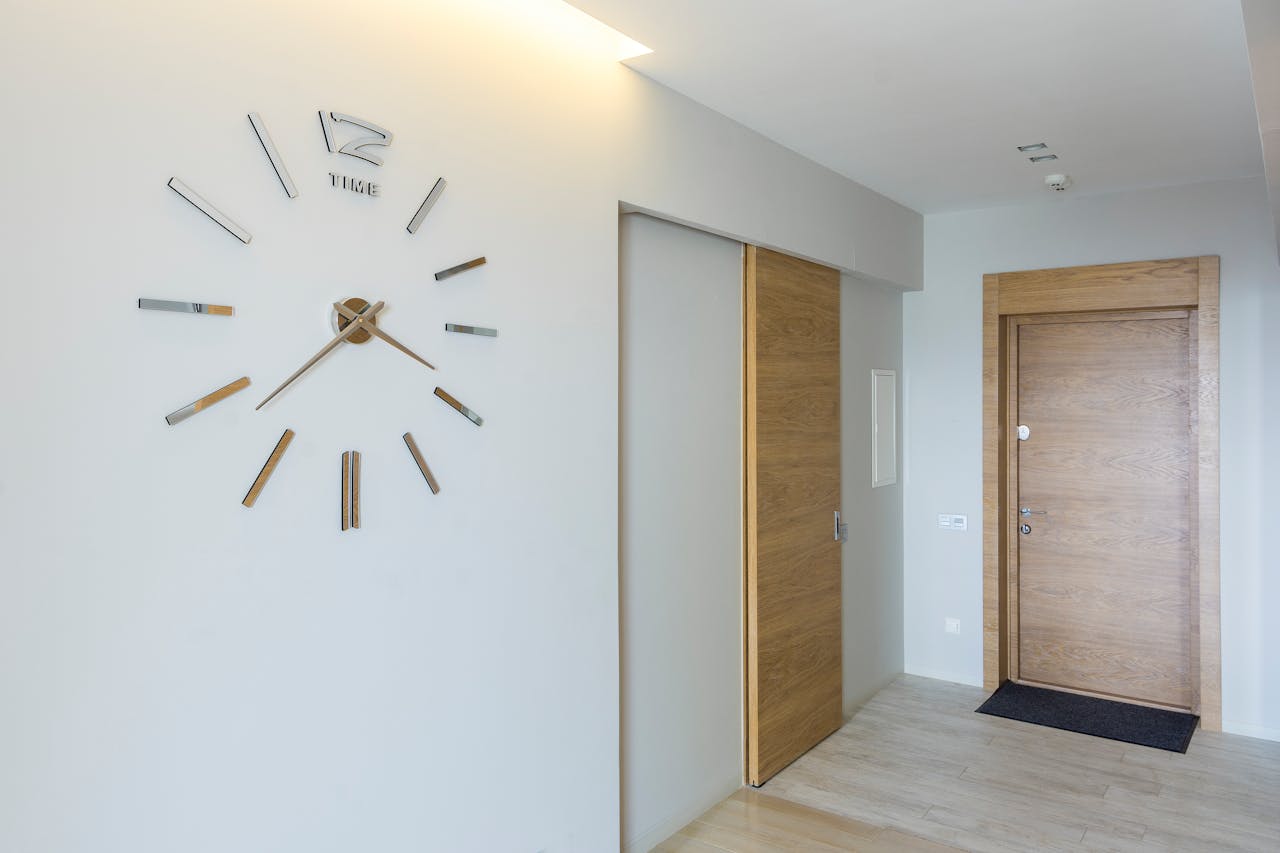 team-01 Elegant modern interior featuring a minimalist wall-mounted clock and wooden doors.